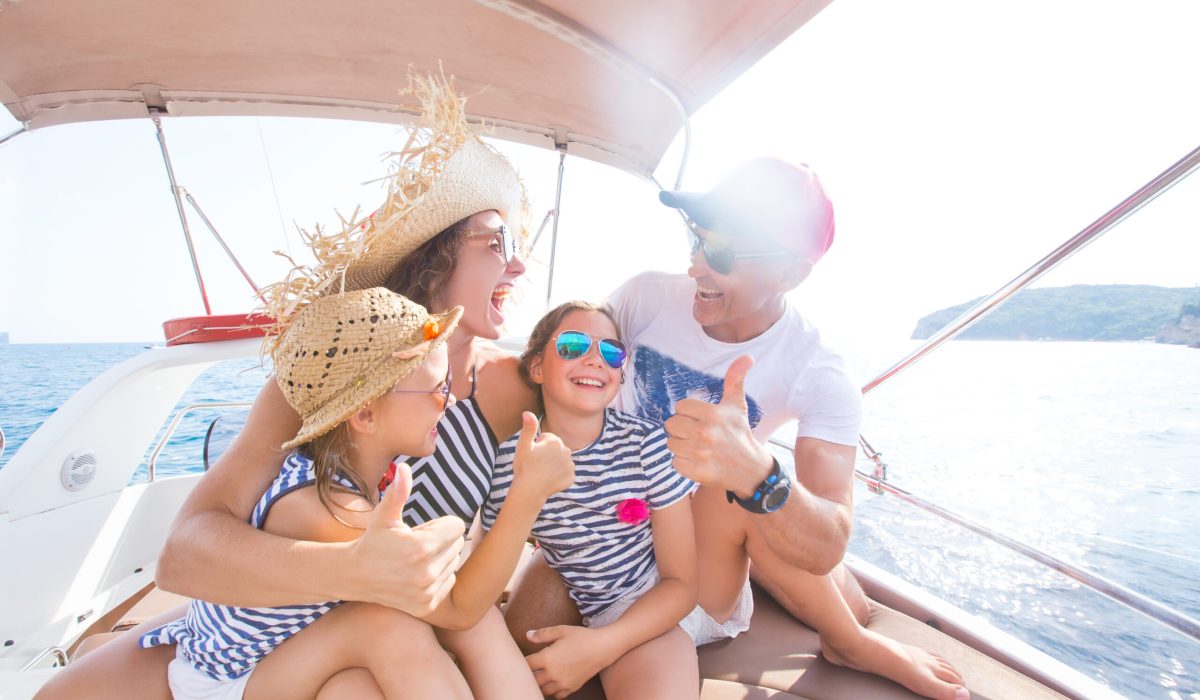 Happy family with children enjoy relaxing on a yacht at sea